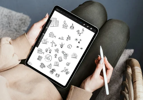 Une graphiste est en train de dessiner des pictos sur tablette grâce au logiciel de dessin Procreate